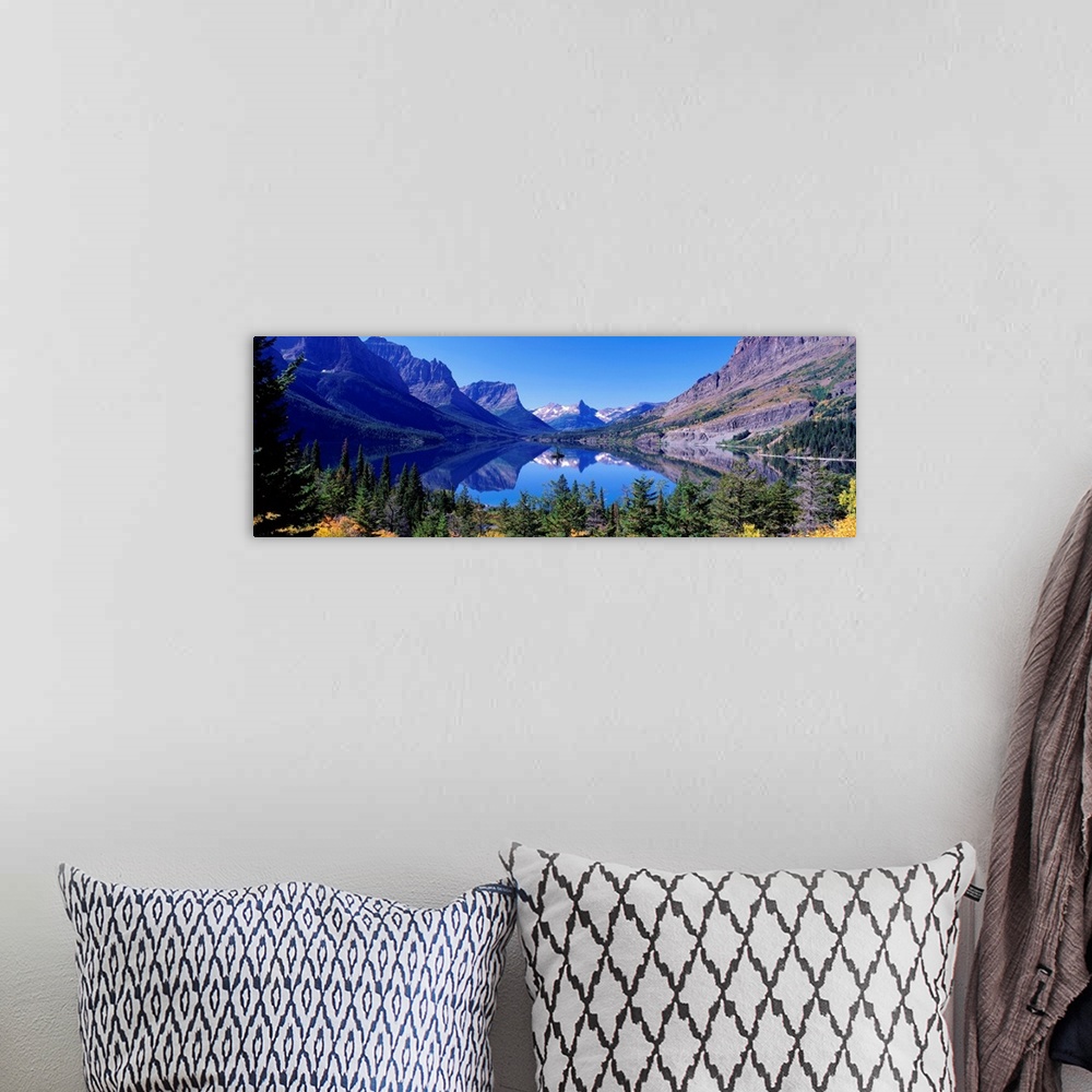 A bohemian room featuring A photographic print of rugged mountains with snow in the distance reflected in a crystal clear l...
