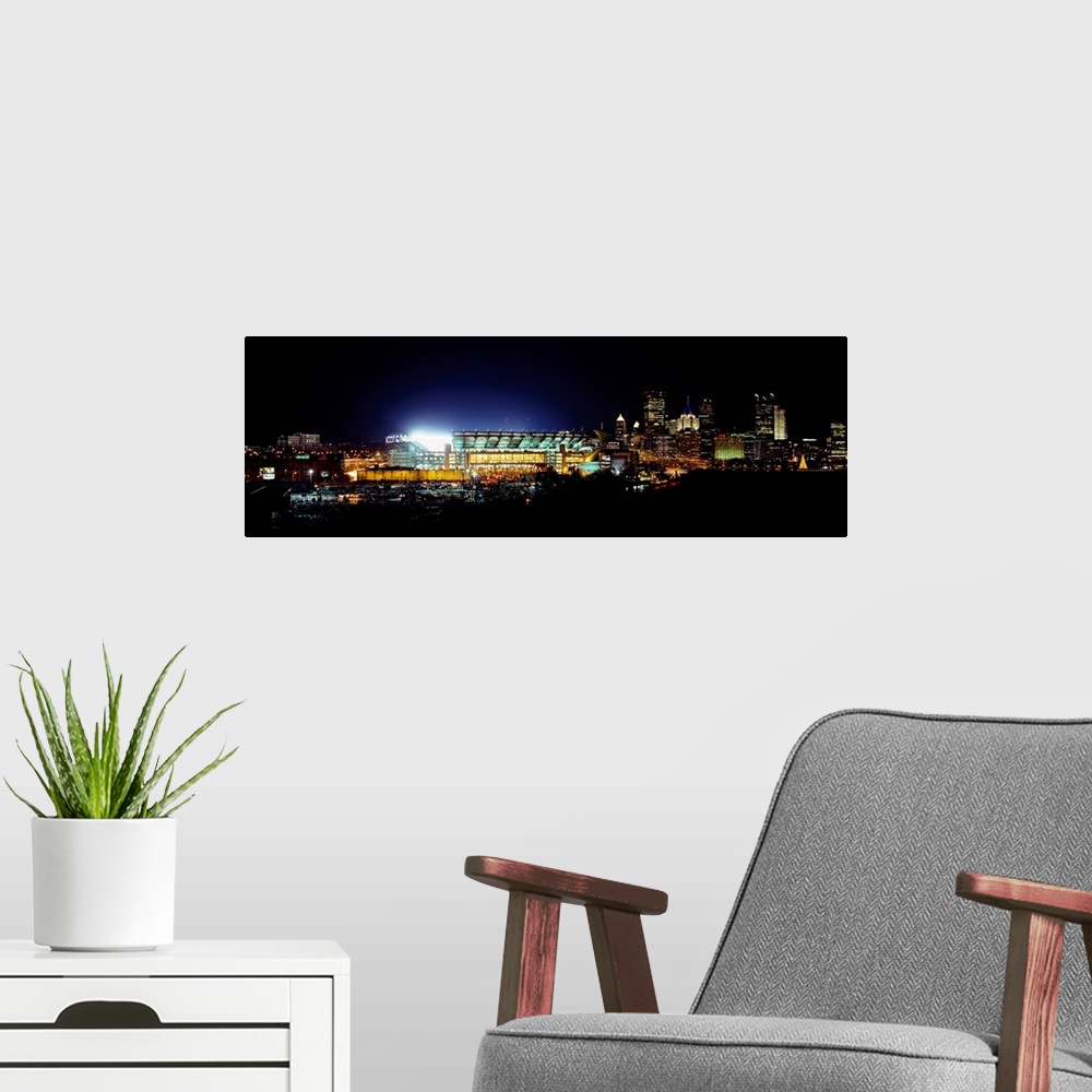 A modern room featuring Panoramic photograph of Heinz Field lit up at night as the Steelers play a football game.  The sk...
