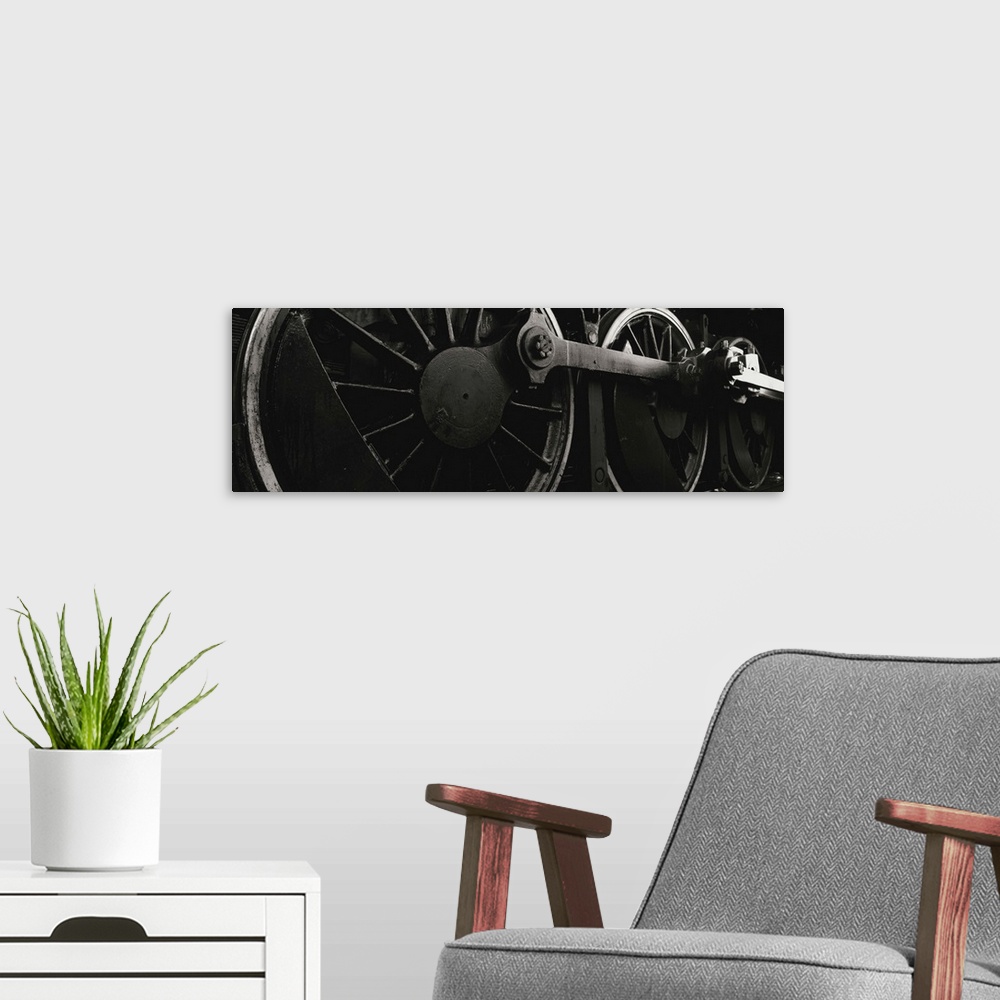 A modern room featuring Panoramic photograph displays a monochromatic close-up looking at the components of a train that ...