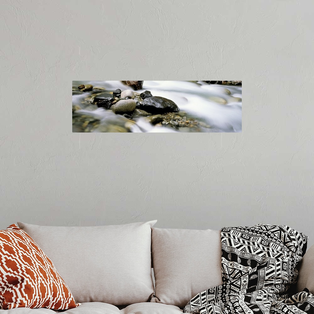 A bohemian room featuring Up-close panoramic photograph of rocky stream with rising mist.