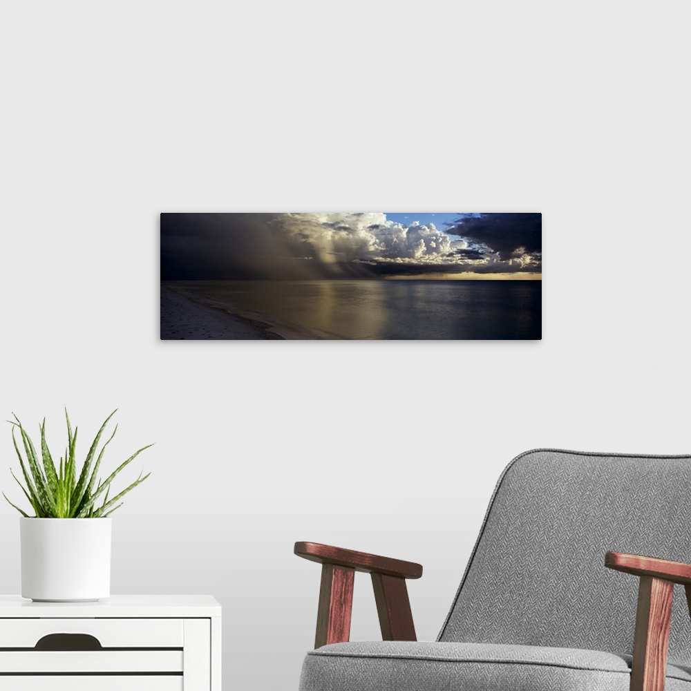 A modern room featuring This is a panoramic photograph of clouds accumulating off shore before sunset.