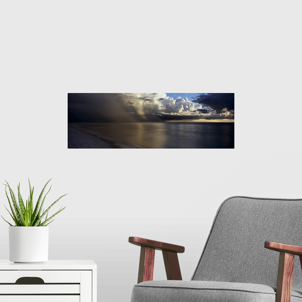 A modern room featuring This is a panoramic photograph of clouds accumulating off shore before sunset.