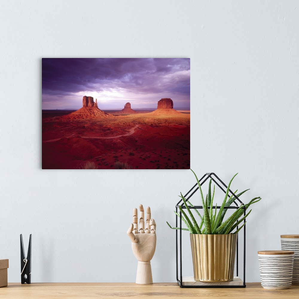 A bohemian room featuring Big photograph shows a barren desert landscape within the Southwestern United States as three gig...