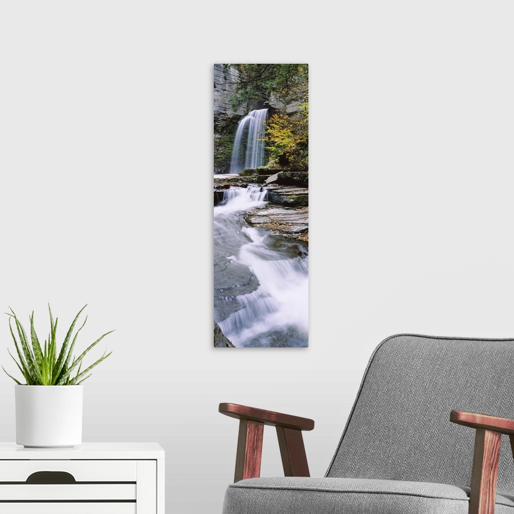 A modern room featuring A continuous cascade of water down flat rocky surfaces captured in a time lapsed photograph in th...
