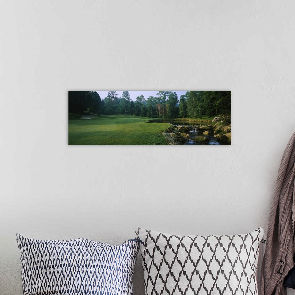 A bohemian room featuring This is a panoramic photograph of a landscaped lawn and trees next to a small cultivated stream.