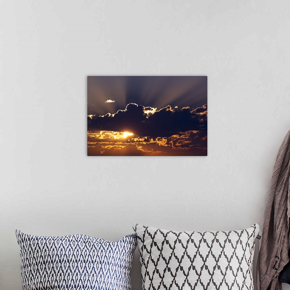 A bohemian room featuring Big canvas photo of the sun peeking through dark clouds.