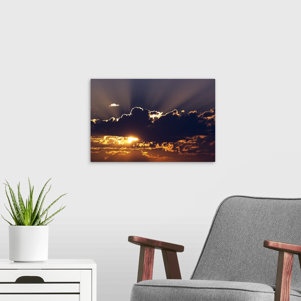A modern room featuring Big canvas photo of the sun peeking through dark clouds.