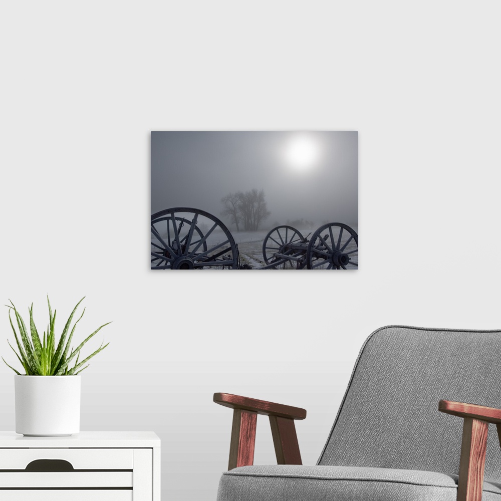 A modern room featuring Sunlight through heavy fog, silhouetted wagon wheels, Gold Creek, Montana