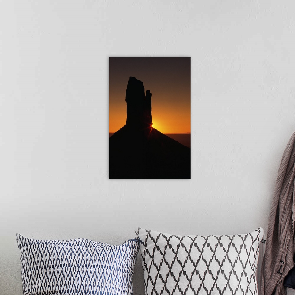 A bohemian room featuring Sunrise behind silhouetted sandstone formation, Monument Valley, Utah