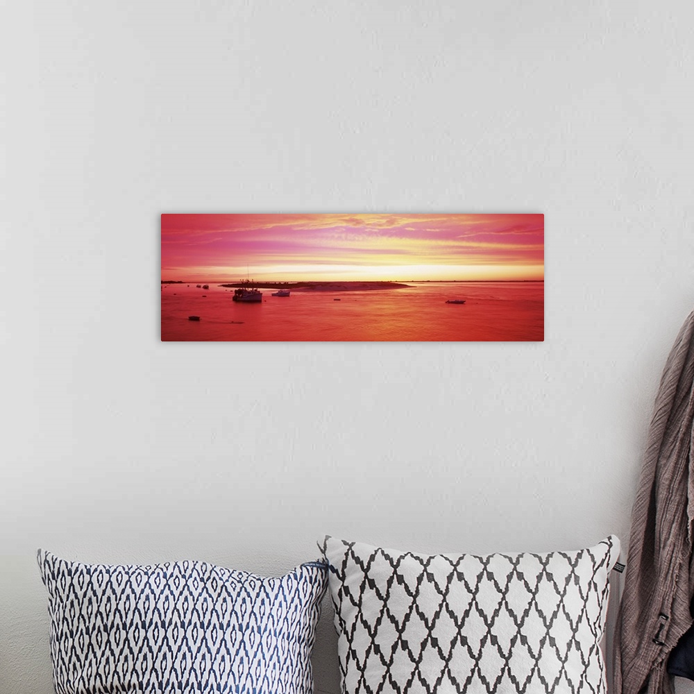 A bohemian room featuring Panoramic image of boats floating in a harbor in Massachusetts while a beautiful sky is painted b...