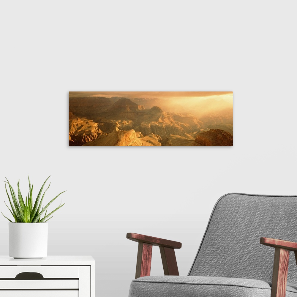A modern room featuring Panoramic photo on canvas of the Grand Canyon bath in warm sunlight from a rising sun.