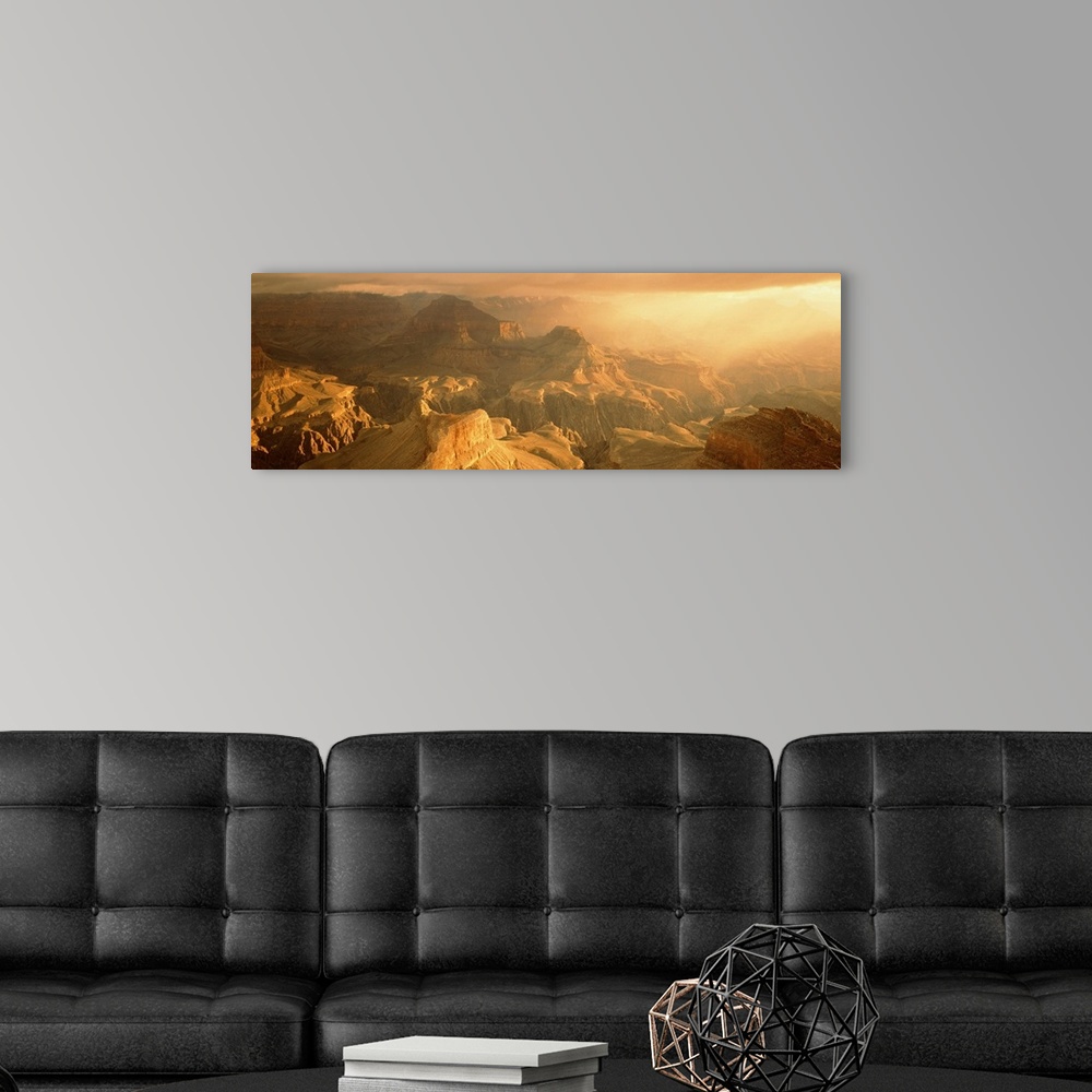 A modern room featuring Panoramic photo on canvas of the Grand Canyon bath in warm sunlight from a rising sun.