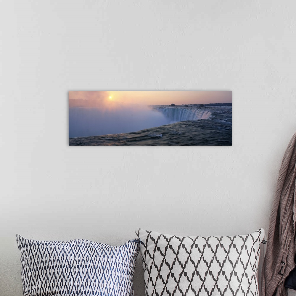 A bohemian room featuring Big canvas print of water rushing down Niagara Falls with the sun rising in the distance.