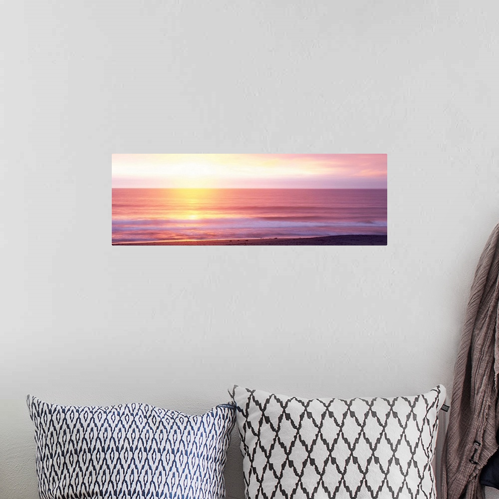 A bohemian room featuring A panoramic photograph taken of the sunrise over a vast ocean off a coast in Hawaii.