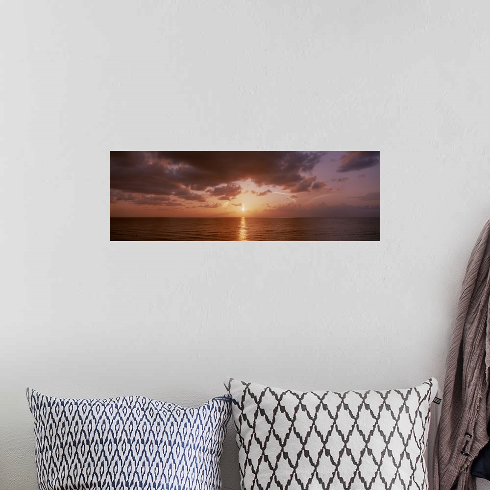 A bohemian room featuring Panoramic photograph of ocean at dawn under a cloudy sky.
