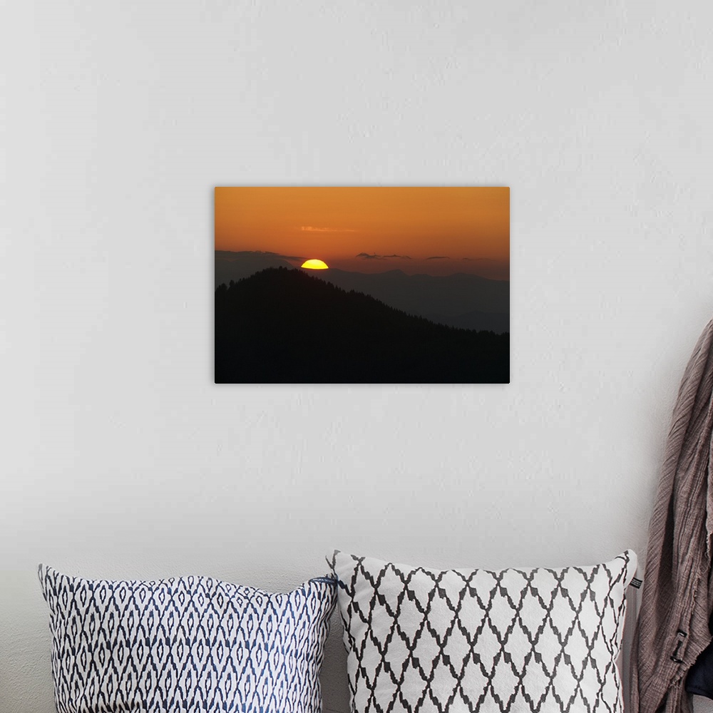 A bohemian room featuring This landscape photograph captures the sun rising above the silhouettes of Appalachian mountains.