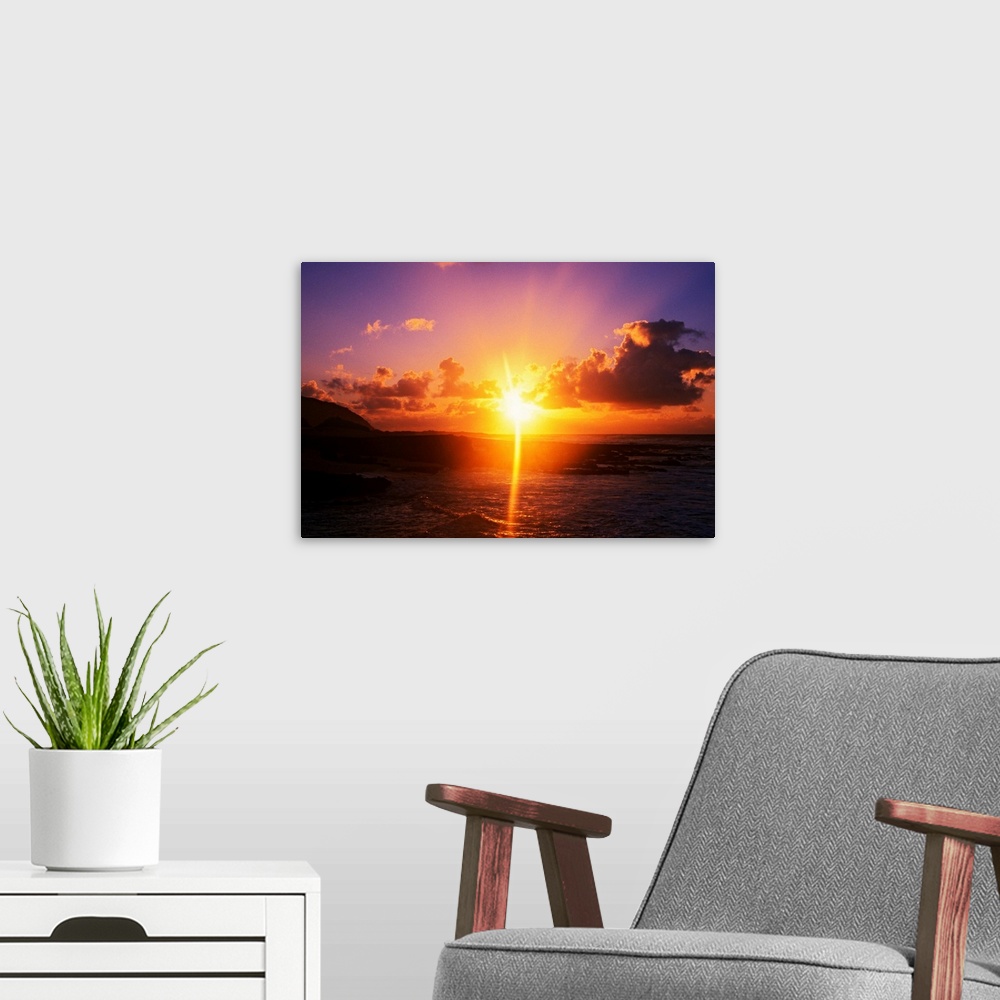 A modern room featuring Giant photograph shows a sunrise over Sandy Beach Park in Oahu, Hawaii.  The brightness of the su...