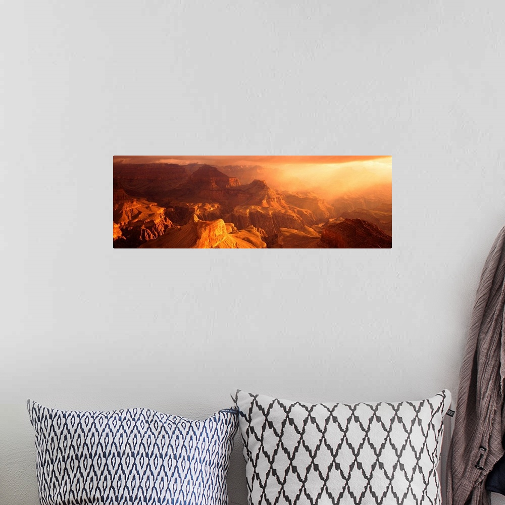 A bohemian room featuring A panoramic photograph of the sunos rays shining on the rocky plateaus emerging from the canyon.