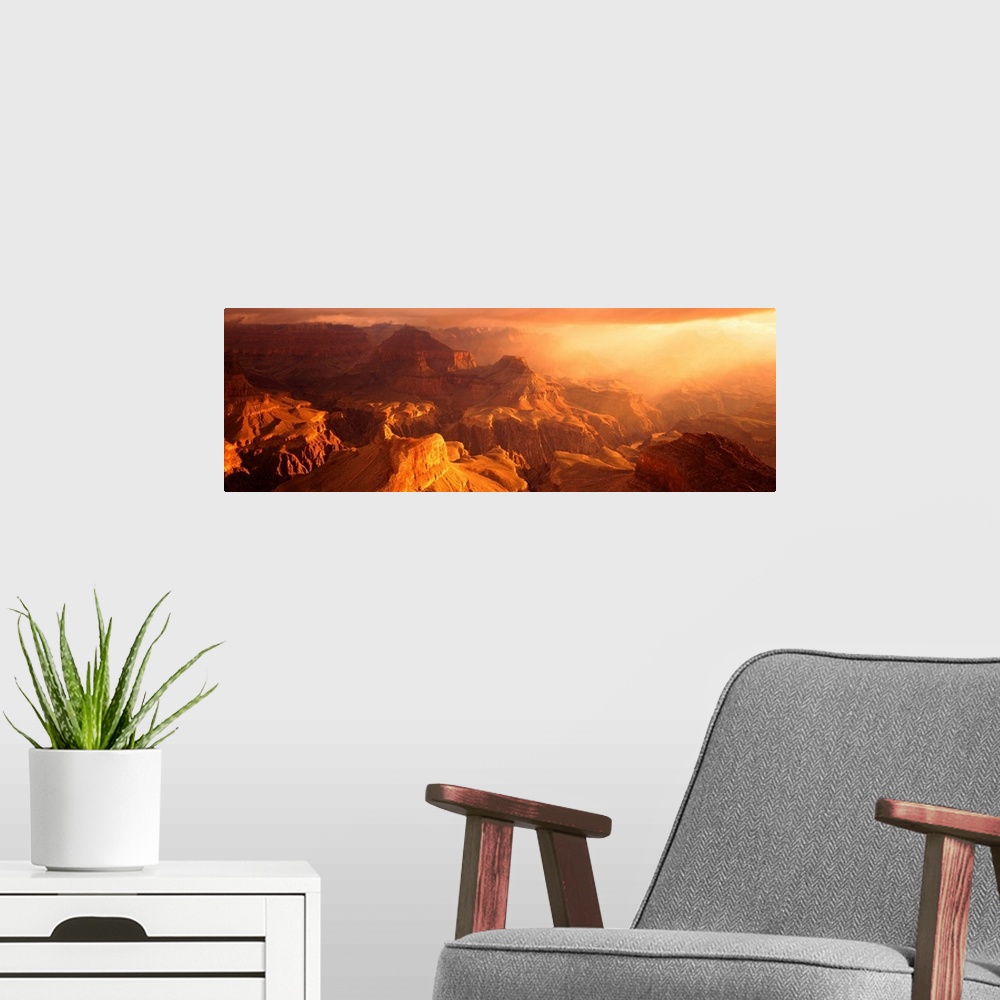 A modern room featuring A panoramic photograph of the sunos rays shining on the rocky plateaus emerging from the canyon.