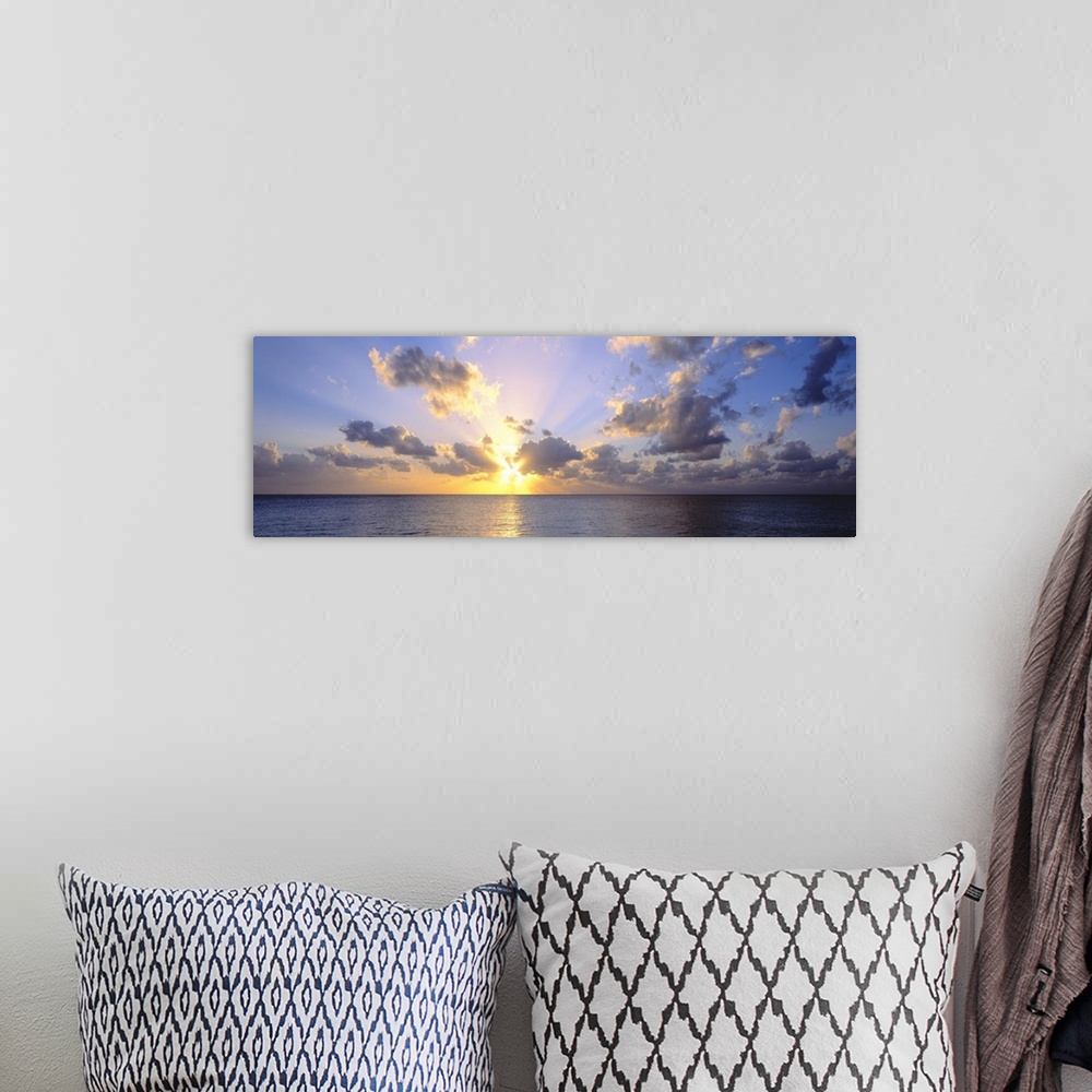 A bohemian room featuring Giant panoramic photograph of the sun about to set in the distance from the perspective of a beac...