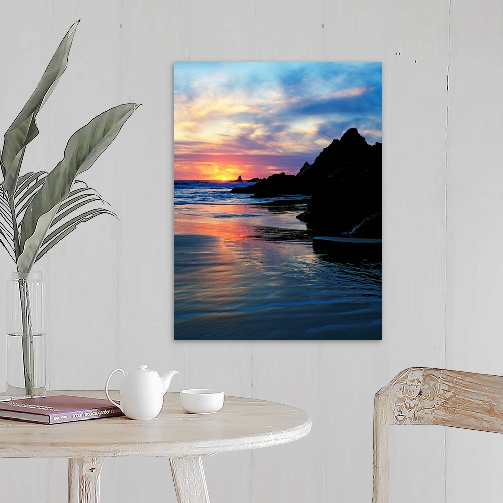 A farmhouse room featuring Sun below the horizon in a seascape with a rocky beach and waves.
