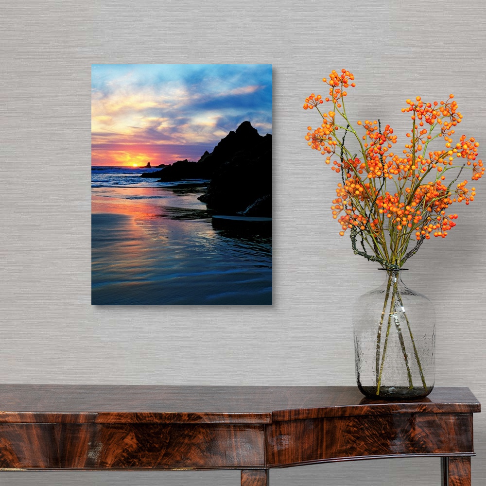 A traditional room featuring Sun below the horizon in a seascape with a rocky beach and waves.