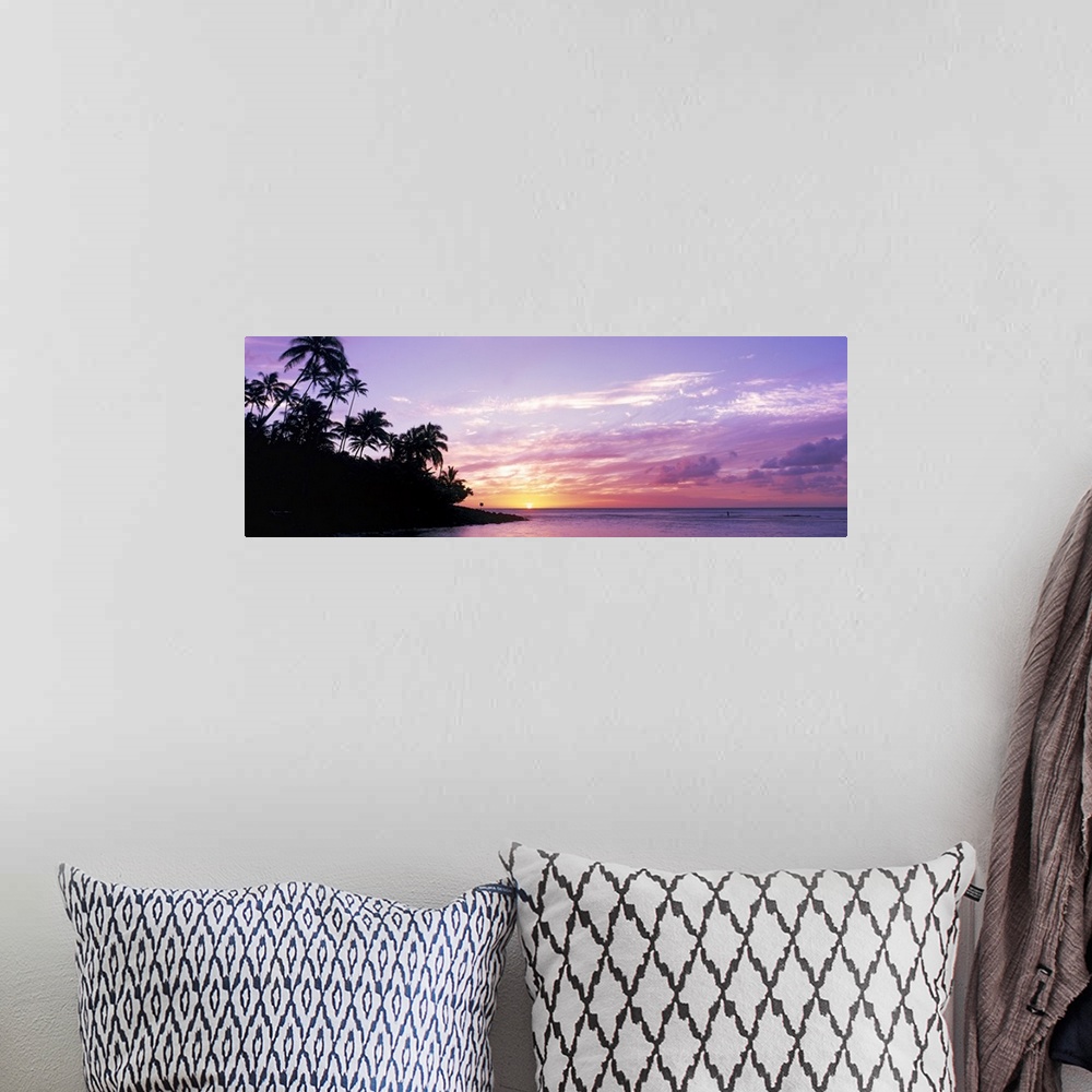 A bohemian room featuring Panoramic photograph displays the sun in the far distance as it begins to set over an island fill...