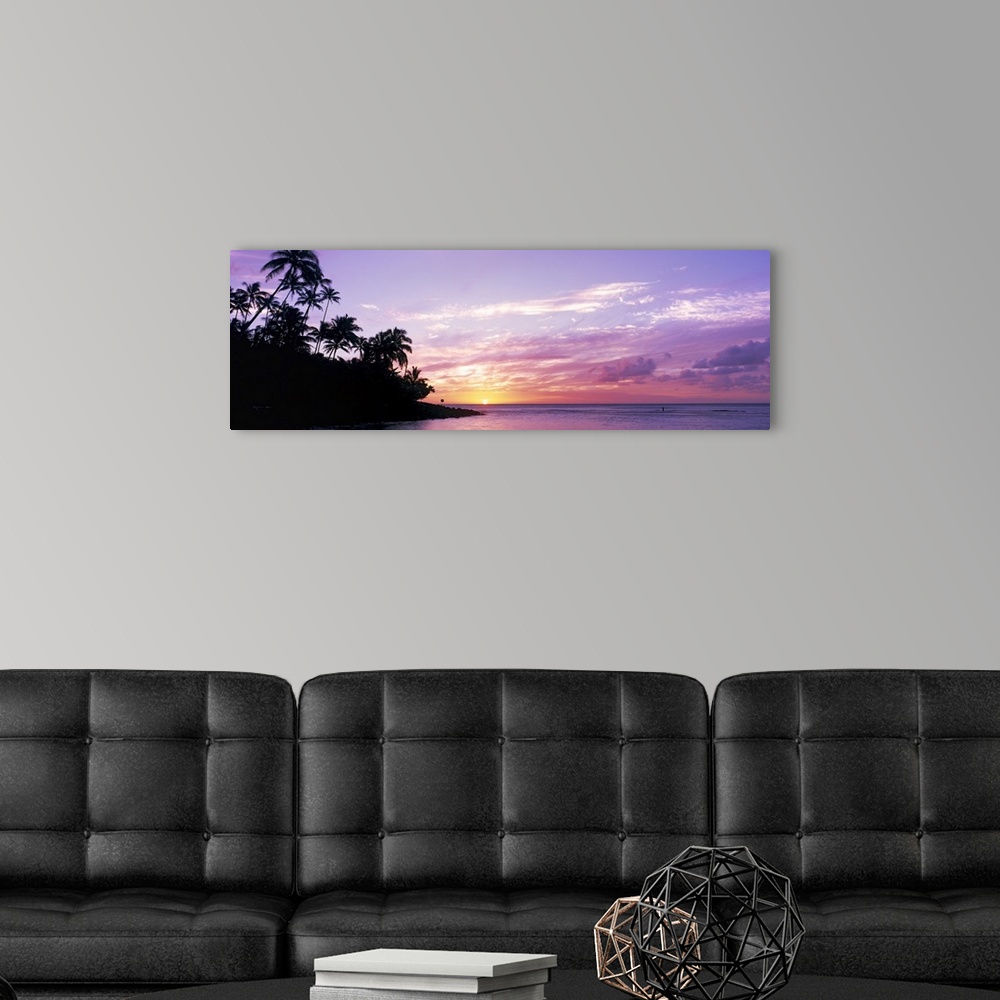 A modern room featuring Panoramic photograph displays the sun in the far distance as it begins to set over an island fill...