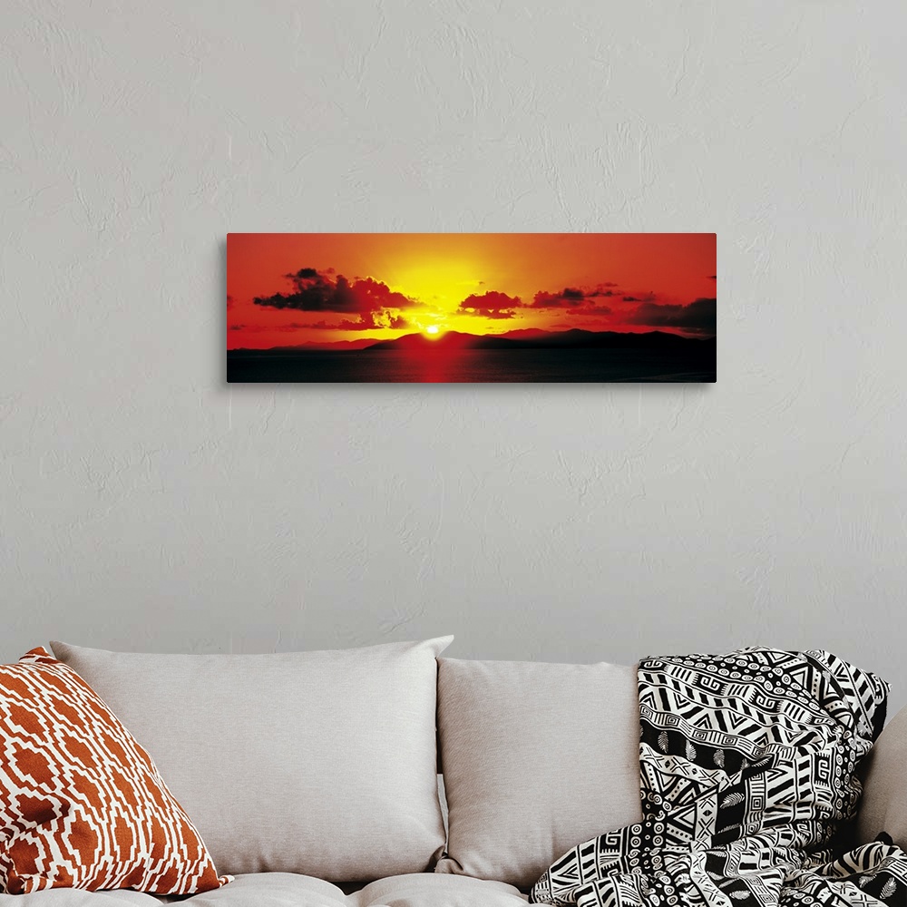 A bohemian room featuring Panoramic photograph of a fiery sunset over a mountain landscape on the horizon, in the British V...