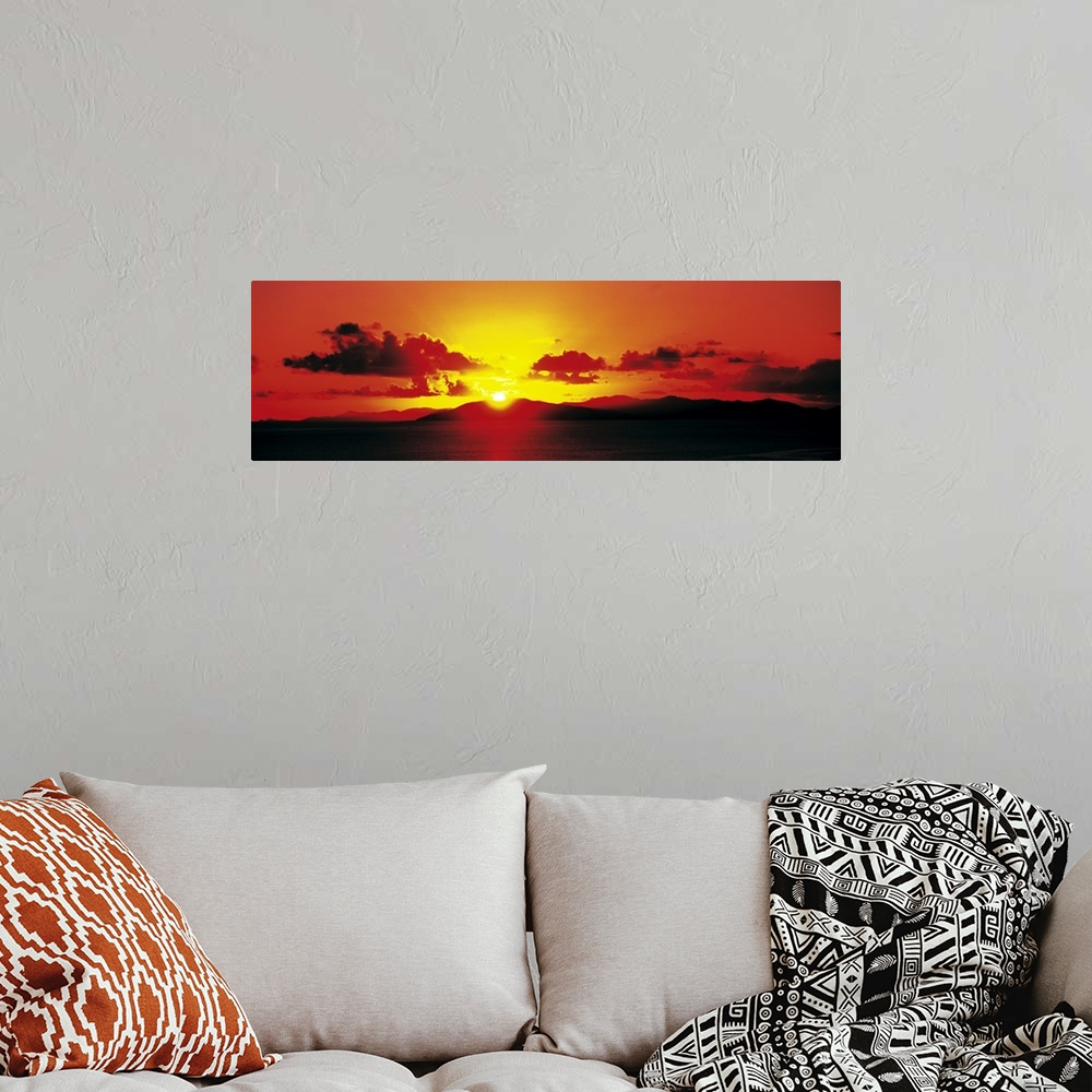 A bohemian room featuring Panoramic photograph of a fiery sunset over a mountain landscape on the horizon, in the British V...