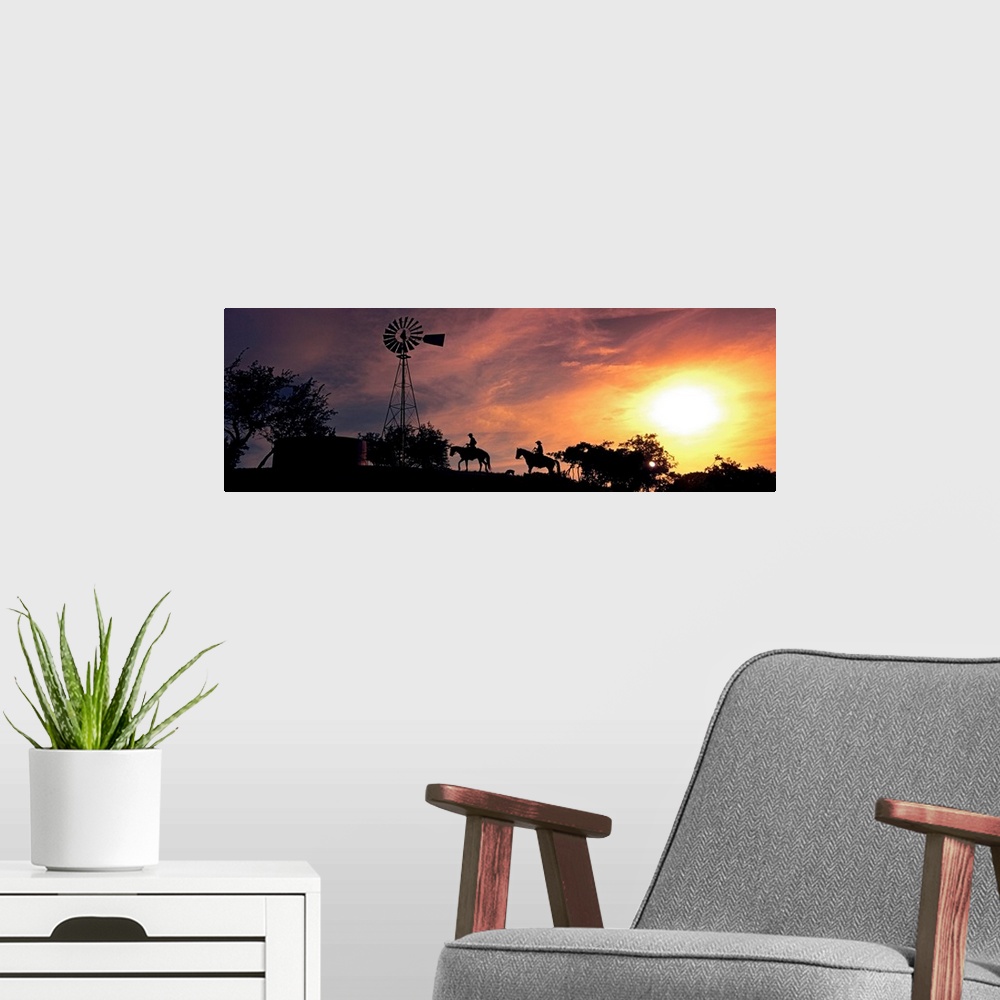 A modern room featuring This panoramic photograph depicts an evening moment on ranch hill side as horseback riders pass b...