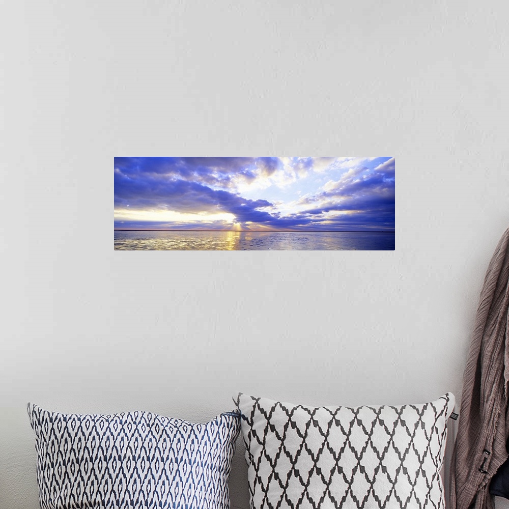 A bohemian room featuring Panoramic photo print of a sunset over an ocean.
