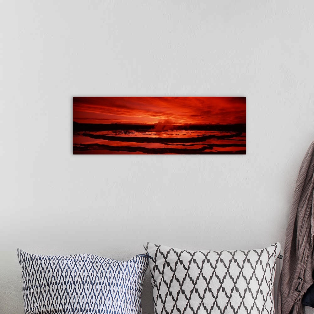 A bohemian room featuring Large canvas photo art of steam coming off a geyser silhouetted against a warm sky.