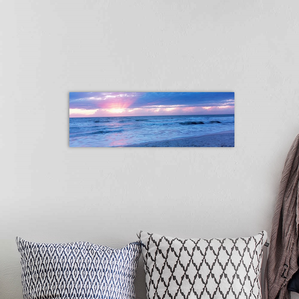 A bohemian room featuring Large panoramic photo of the sun setting over a beach in Naples, Florida (FL).
