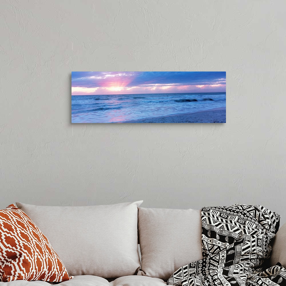 A bohemian room featuring Large panoramic photo of the sun setting over a beach in Naples, Florida (FL).