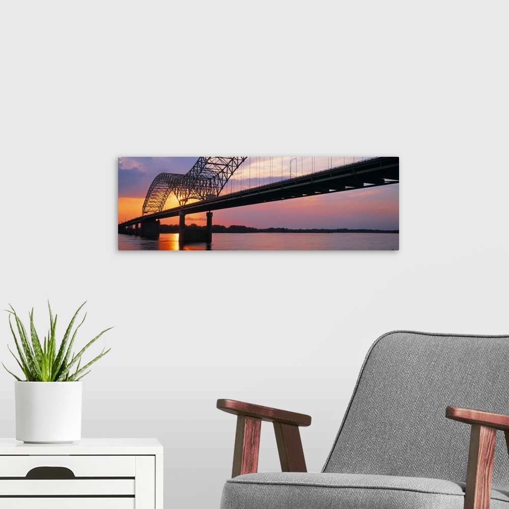 A modern room featuring Picture taken of the sunset through a bridge over the Mississippi river.