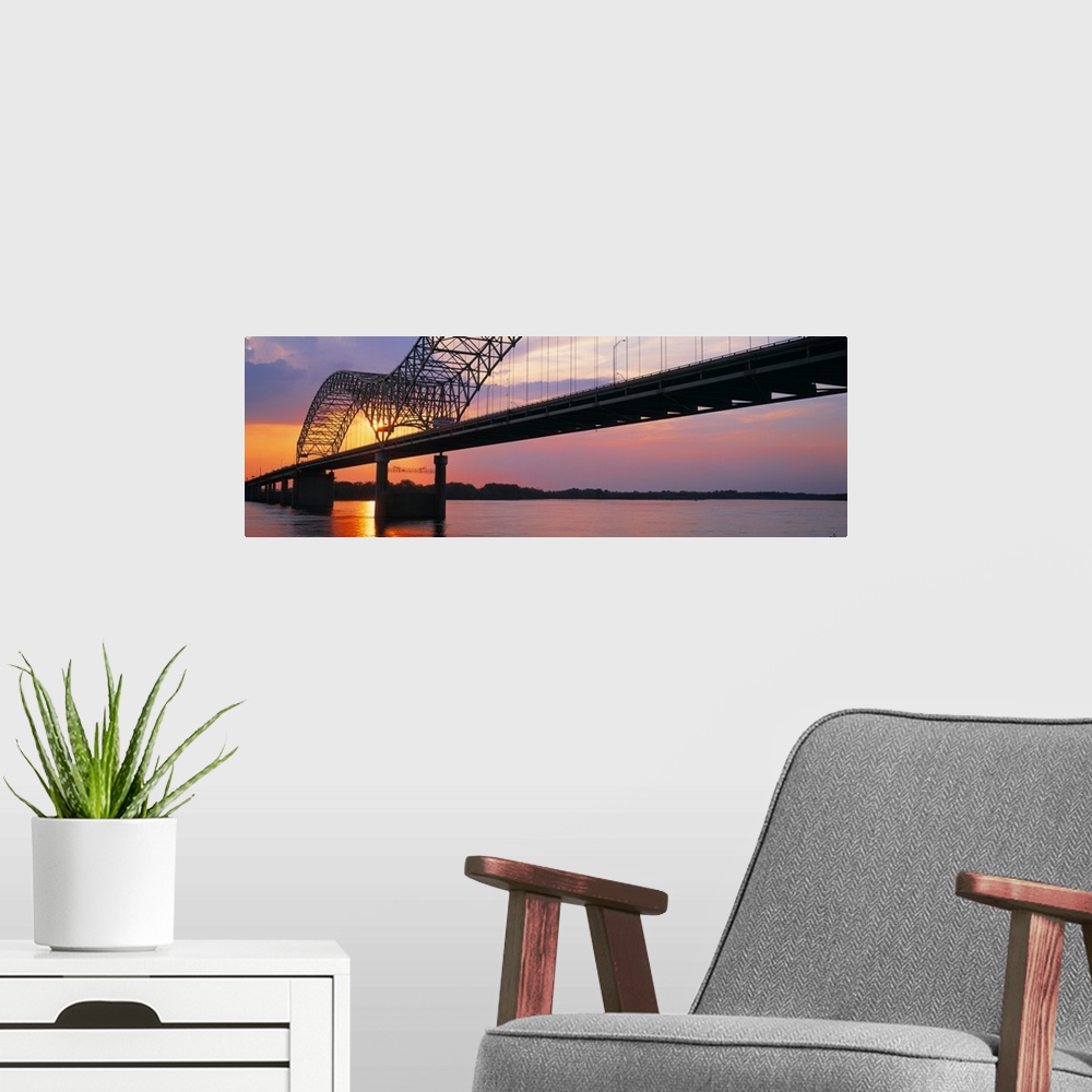 A modern room featuring Picture taken of the sunset through a bridge over the Mississippi river.
