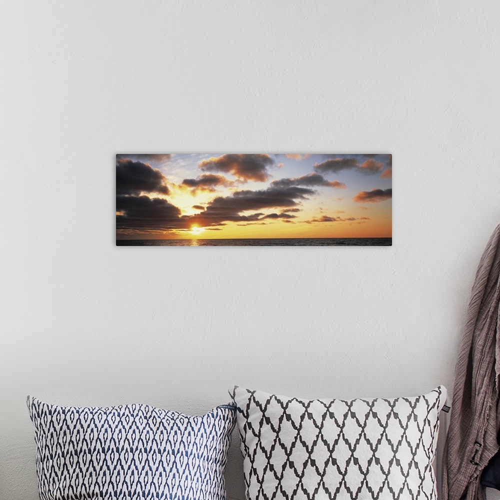 A bohemian room featuring Wide angle photograph of the sun setting slightly behind clouds, over the vast waters of Lake Mic...