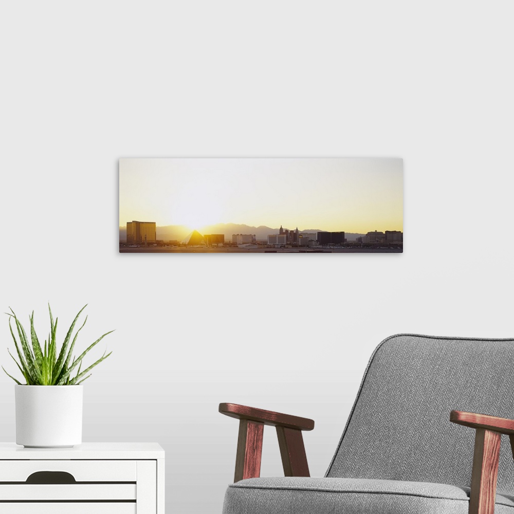 A modern room featuring Panoramic picture taken of the strip in Las Vegas with a bright sun setting behind the mountains ...
