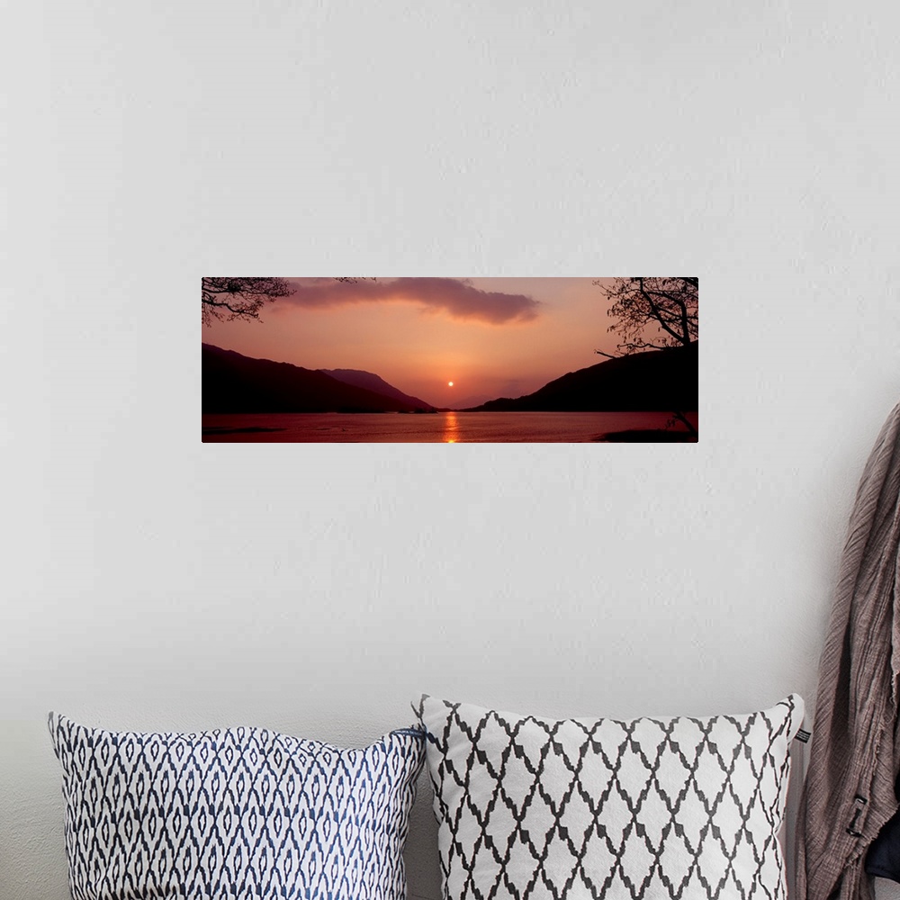 A bohemian room featuring Panoramic photo on canvas of a sunset over the water with rolling hills in the background.