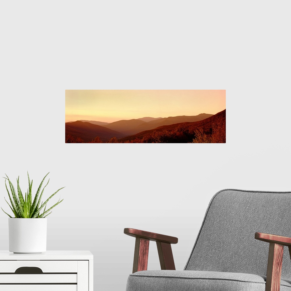 A modern room featuring Large panoramic image of rolling mountains in the foggy sunset.