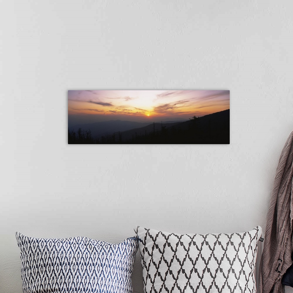 A bohemian room featuring Landscape photograph on a giant canvas of the sun setting behind wispy clouds, over Clingmans Dom...