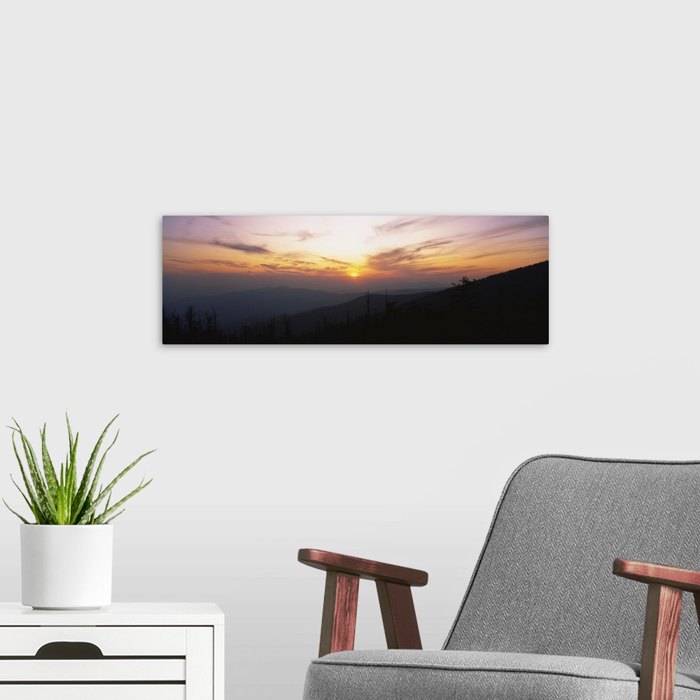 A modern room featuring Landscape photograph on a giant canvas of the sun setting behind wispy clouds, over Clingmans Dom...