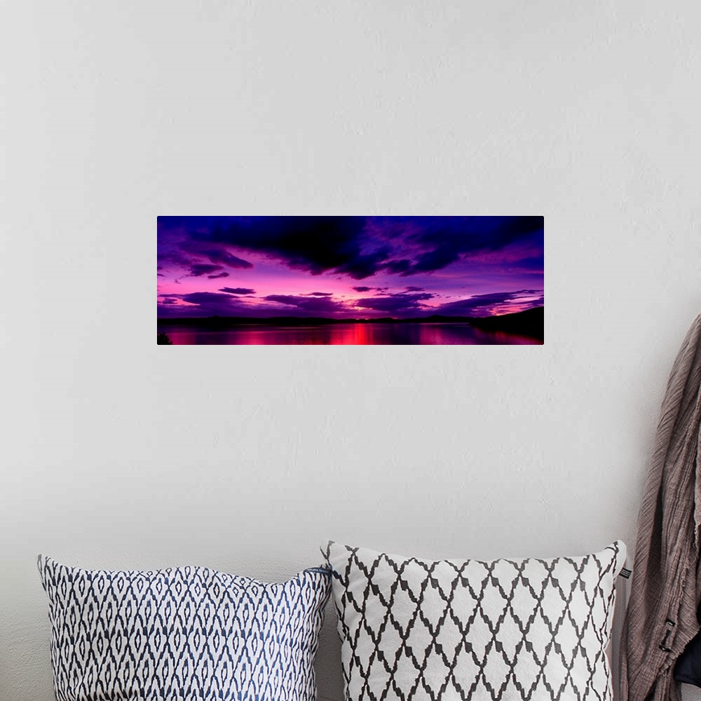 A bohemian room featuring A panoramic photograph of clouds in the sky and light reflecting off water in the twilight colors.