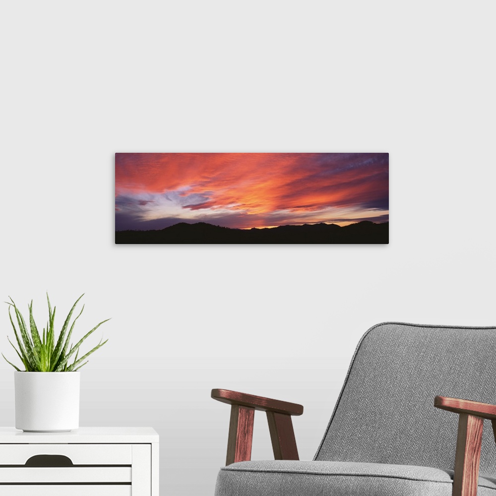 A modern room featuring Panoramic photograph on a large wall hanging of the Black Hills National Forest silhouetted benea...