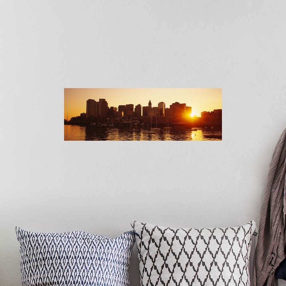 A bohemian room featuring The sun breaks though the skyscrapers in downtown Boston, Massachusettes (MA) as the sun sets and...