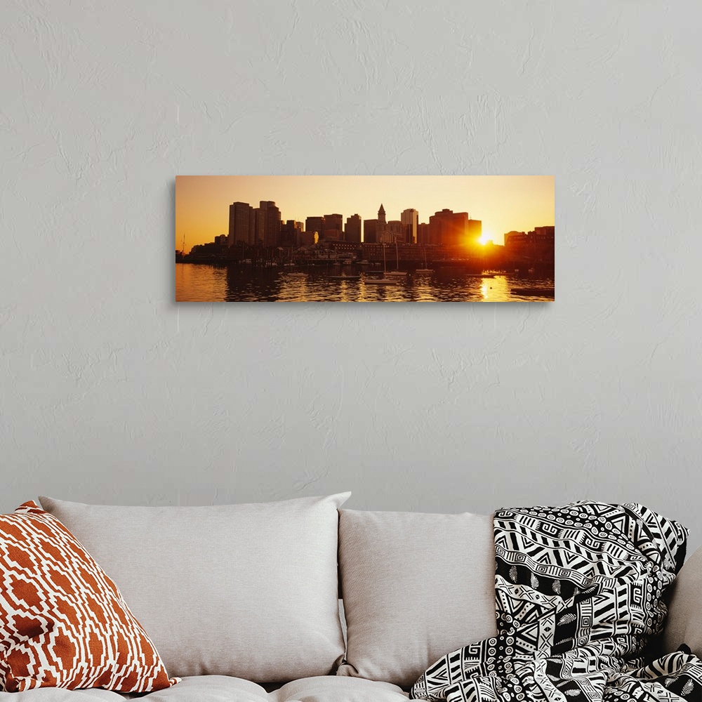 A bohemian room featuring The sun breaks though the skyscrapers in downtown Boston, Massachusettes (MA) as the sun sets and...