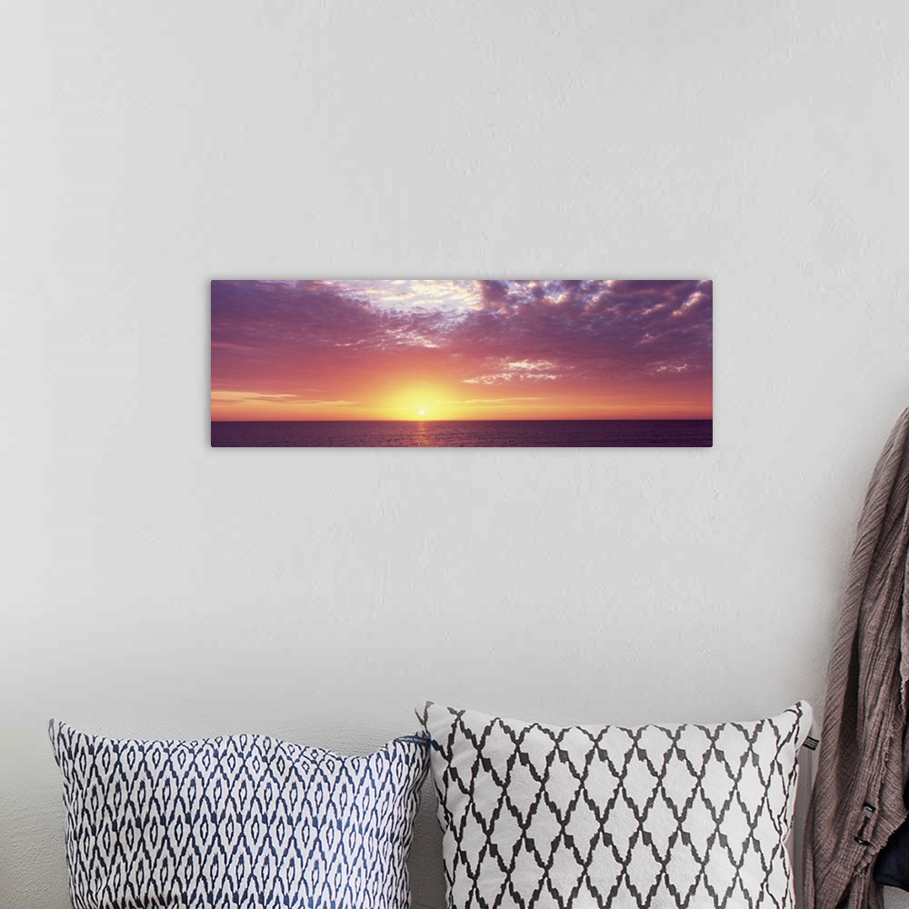 A bohemian room featuring Panoramic photo of a beautiful sunset over the ocean.