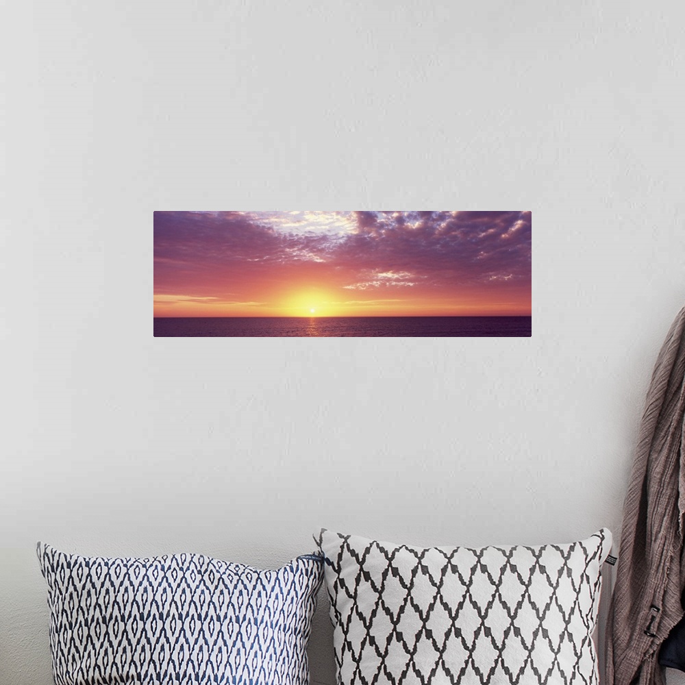 A bohemian room featuring Panoramic photo of a beautiful sunset over the ocean.