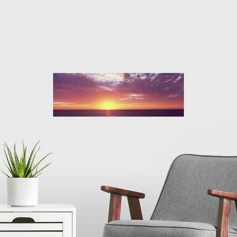 A modern room featuring Panoramic photo of a beautiful sunset over the ocean.